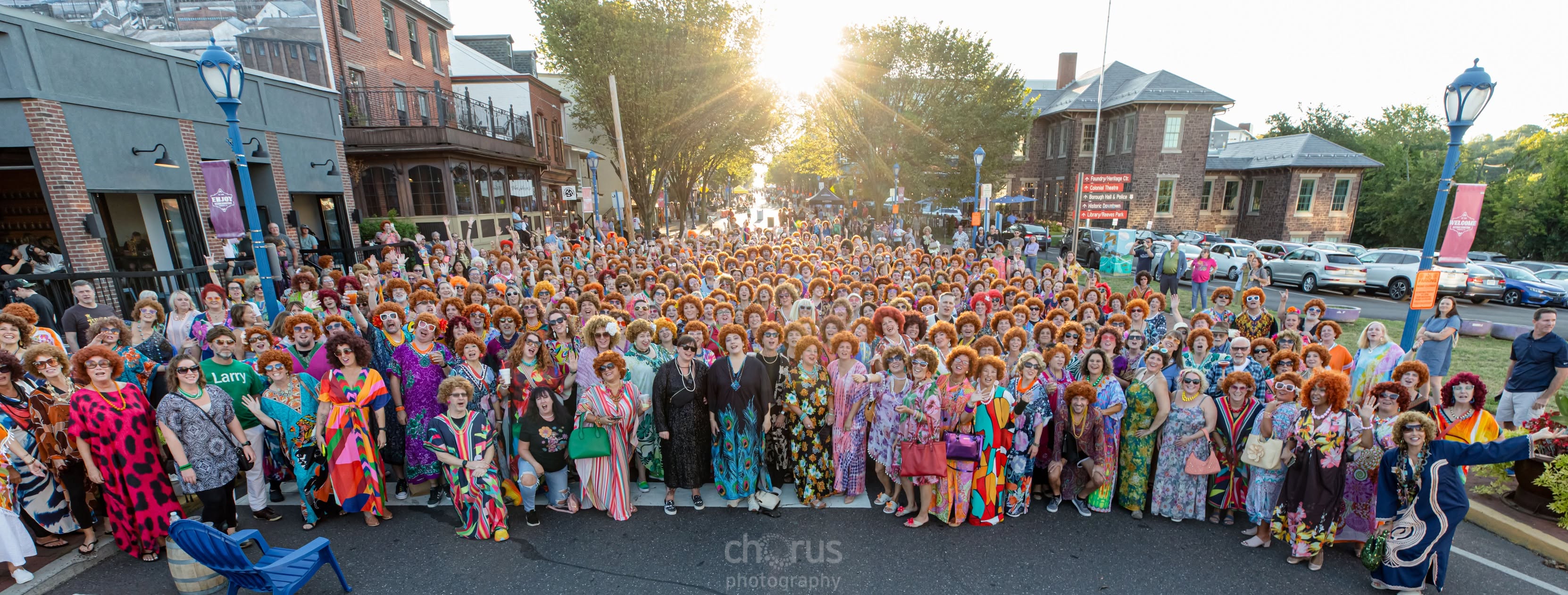 A huge crowd of Phoenixville Roper Romp participants in colorful caftans and red wigs